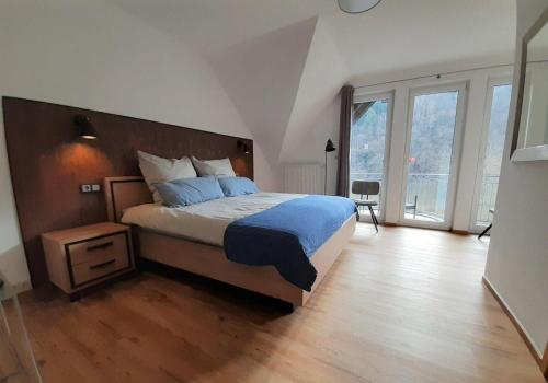 Un dormitorio con una cama y una ventana grande. en Haus-Moselliebe-Charmantes-Fruehstuecks-Zimmer-mit-Balkon-und-Blick-auf-die-Mosel-Raucherfreihaus, en Ediger-Eller