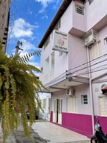 a white and pink building with a sign on it at Pousada Santa Rosa in Aparecida