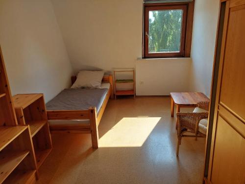 a room with a bed and a table and a window at Monteurzimmer bei der Gärtnerei in Grünendeich
