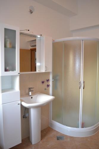 a white bathroom with a sink and a shower at Apartment Greta,50 METERS TO THE BEACH in Banjole