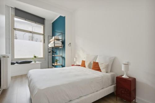 a bedroom with a large white bed and a window at Cosy renovated studio in heart of Paris XVieme in Paris