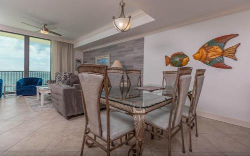 a dining room with a glass table and chairs at Phoenix IX 1105 condo in Orange Beach
