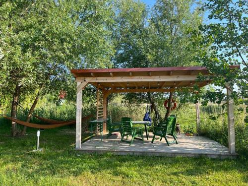 a gazebo with a table and chairs and a hammock at Liwia Park Green House in Niechorze