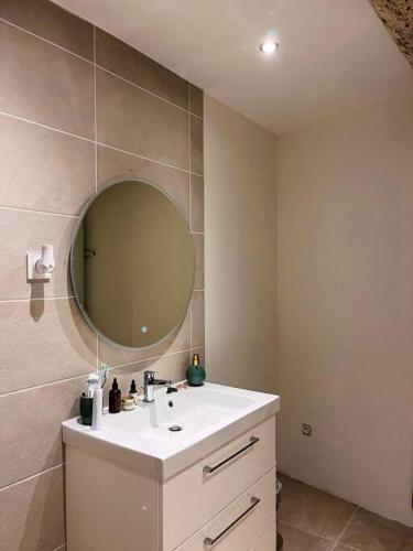 a bathroom with a sink and a mirror at Appartement charmant et calme dans l’Hérault in Poussan