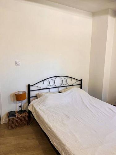 een slaapkamer met een bed met een witte sprei bij Appartement charmant et calme dans l’Hérault in Poussan