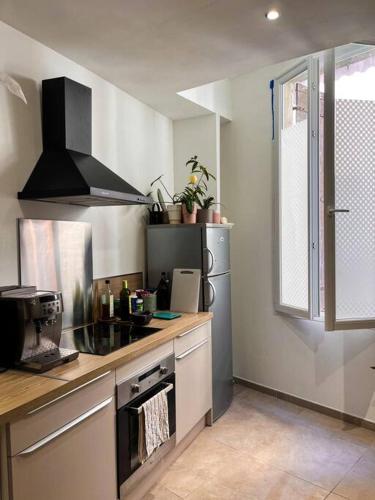 een keuken met een wastafel en een fornuis top oven bij Appartement charmant et calme dans l’Hérault in Poussan