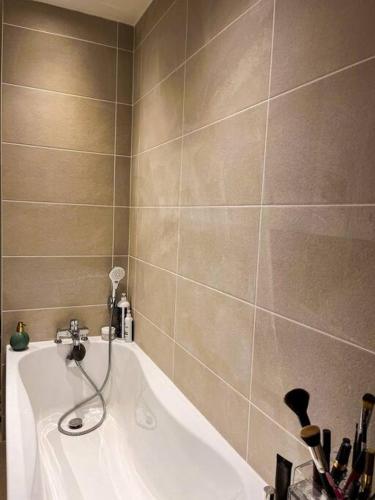 een badkamer met een bad en een douche bij Appartement charmant et calme dans l’Hérault in Poussan