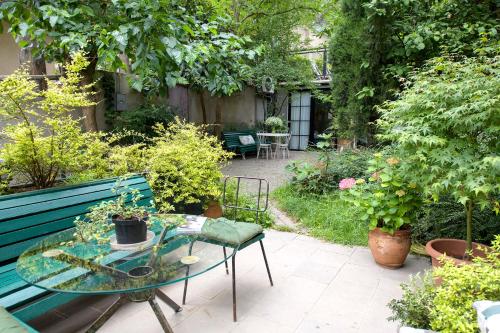a garden with a blue bench and a table with plants at Funicular Inn Apartments in Tbilisi City