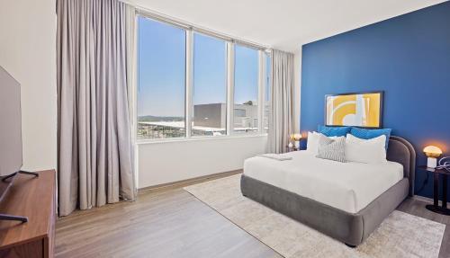 a bedroom with a large bed and a large window at Placemakr Premier SoBro in Nashville