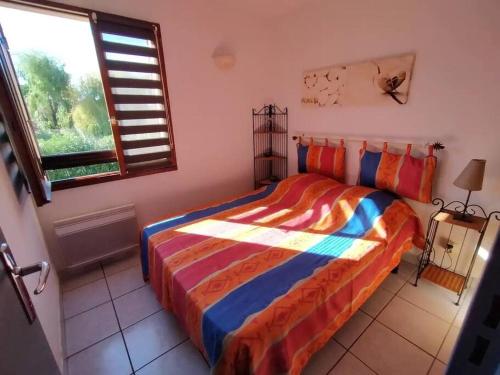 - une chambre avec un lit et une couverture colorée dans l'établissement Appt bord de mer deux chambres et piscine, à Argelès-sur-Mer