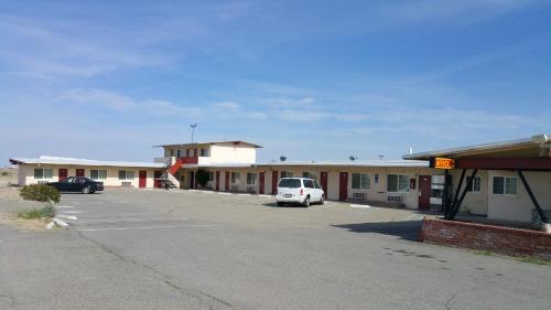 een auto geparkeerd op een parkeerplaats voor een motel bij Budget Inn Mojave in Mojave