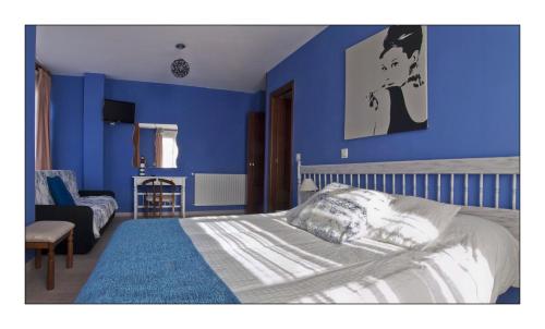 a bedroom with blue walls and a bed and a chair at Hotel Rural en Escalante Las Solanas in Escalante