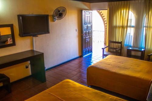 Habitación de hotel con cama y TV de pantalla plana. en Hotel Villa Capri en Morelia