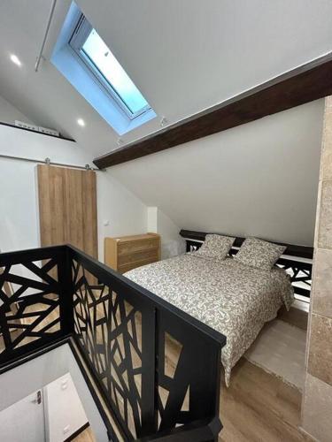 une chambre avec un lit et une lucarne dans l'établissement Le Darcy, grand appartement centre ville Dijon, proche gare, à Dijon