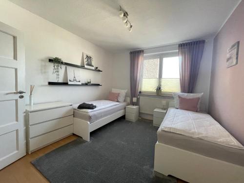 1 Schlafzimmer mit 2 Betten, einem Schreibtisch und einem Fenster in der Unterkunft WH-Immobilien:Citynah mit Balkon in Hannover
