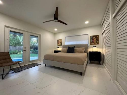 um quarto com uma cama e uma ventoinha de tecto em The Sun House - 3 Bed, 2 Bath, Private Pool, Fire Pit, Huge Backyard em Fort Lauderdale