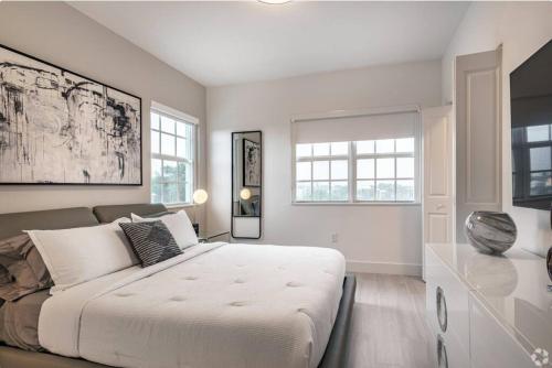 1 dormitorio blanco con 1 cama grande y ventanas en Dahlia - The Designer Townhome, en Lake Worth