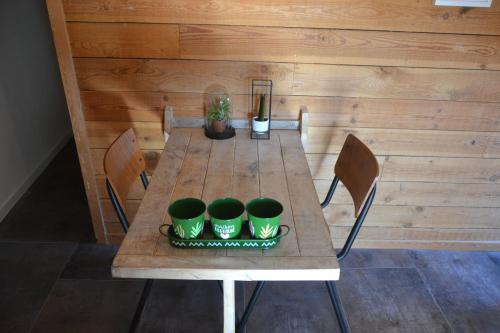 a wooden table with four green plants on it at La Jo Welcome Home in Theux