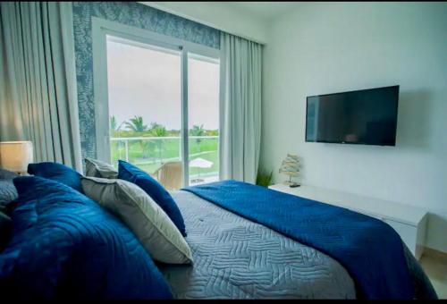 a bedroom with a blue bed with a large window at Hard Rock at Cana Rock 1 by Unwind Properties in Punta Cana