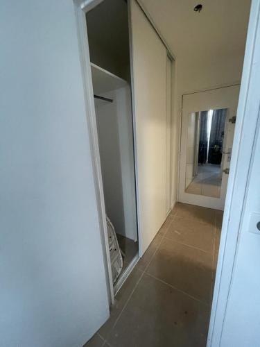 une chambre avec un miroir et une chambre avec un couloir dans l'établissement Joli studio entre Paris et Disneyland, à Villemomble