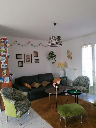 een woonkamer met een bank en een tafel bij Chambre au coeur de la Sologne in Romorantin