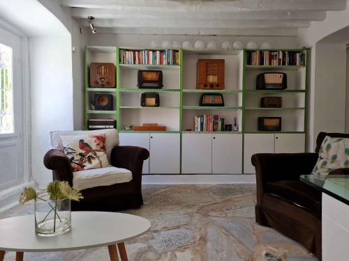 uma sala de estar com duas cadeiras e uma mesa em Hotel Omiros em Ermoupoli