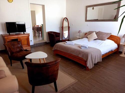 Schlafzimmer mit einem Bett, einem Spiegel und einem Tisch in der Unterkunft Beau logement proche plage et centre-ville in La Tranche-sur-Mer