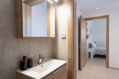 a bathroom with a sink and a mirror at Cycladic Sunlight 2bedroom House in Krotiri