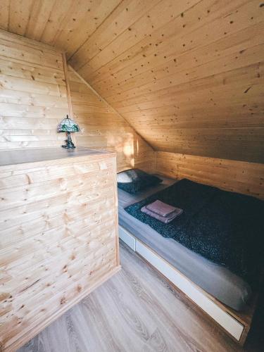 a room with two beds in a wooden cabin at U Progu Lasu in Budy