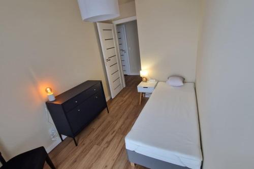 una piccola camera con letto e cassettiera di Piękny apartament z widokiem a Katowice