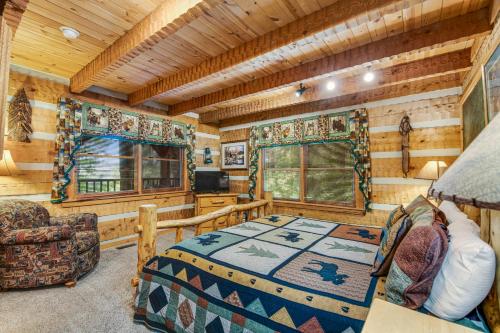 a log cabin bedroom with a bed and a television at Smokies Sanctuary in Hatchertown