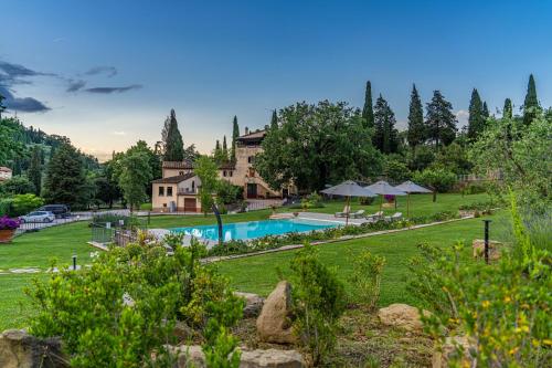 une maison avec une piscine dans un parc dans l'établissement Villa D'Epoca Carniani, à Arezzo