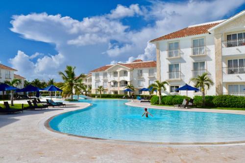 uma pessoa a nadar numa piscina num resort em Cadaques Caribe Bayahibe Apartments em La Fragata