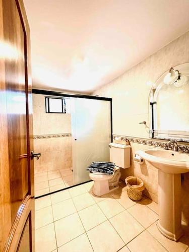 a bathroom with a shower and a toilet and a sink at Casa Ritual tu refugio con jardín & 4 recámaras in Oaxaca City