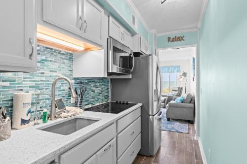 uma cozinha com um lavatório e um frigorífico em Turtle Cove Retreat em Atlantic Beach