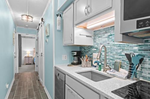 a kitchen with white cabinets and a sink at Turtle Cove Retreat in Atlantic Beach