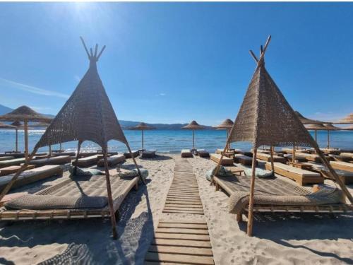 un gruppo di sedie a sdraio e ombrelloni sulla spiaggia di Beach front apartment Psili Ammos a Psilí Ámmos