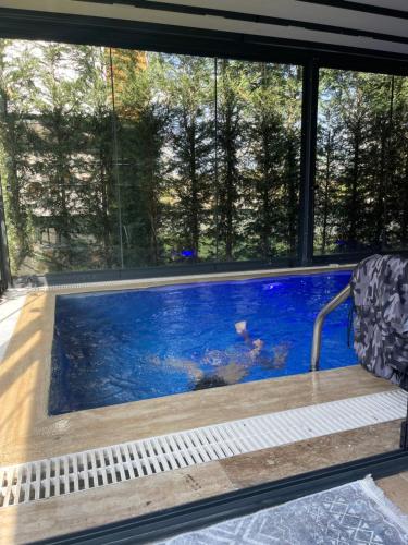 uma piscina num quarto com janelas em Emela Villa em Sapanca