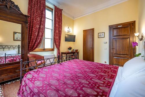 a bedroom with a large pink bed and a window at Soggiorno Campos in Florence