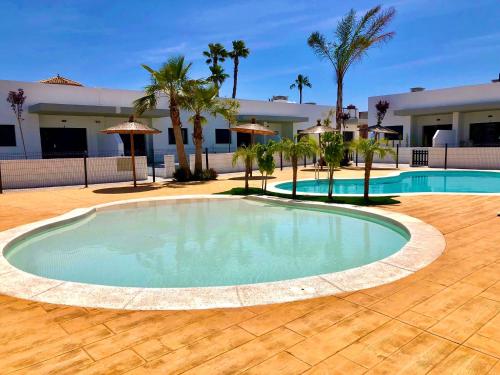 una gran piscina en un patio con palmeras en Villa Salamander en El Verger