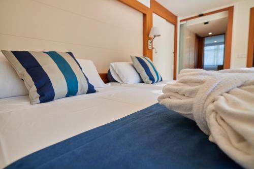 a bedroom with two beds with blue and white pillows at Los Geranios in Port de Soller
