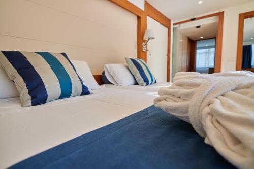 a large white bed with blue and white pillows at Los Geranios in Port de Soller