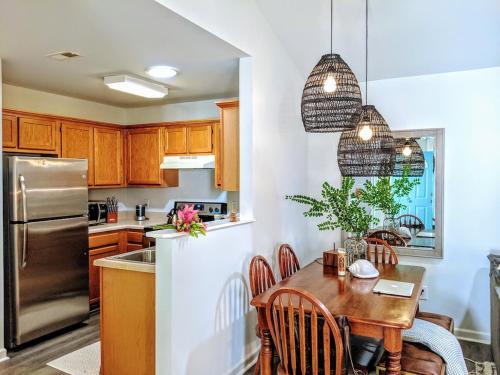 a kitchen with a table and a stainless steel refrigerator at RARE Downtown Matthews walk 2 shops restauraunts hike CLT 2 Bedroom not 3br in Charlotte