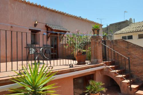 a balcony with stairs and potted plants on a building at Casa rural La Boticaria in Villar del Arzobispo