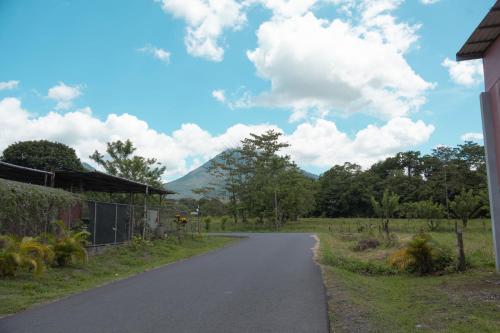 a winding road with a mountain in the background at La Fortuna Living - Room in Fortuna