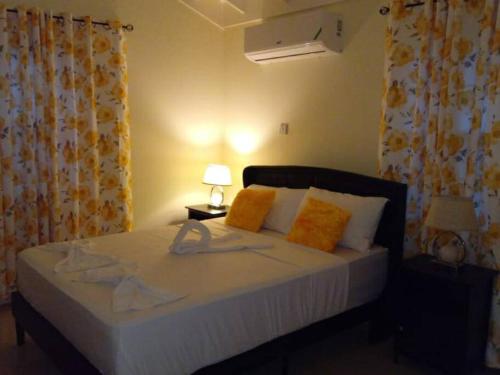 a bedroom with a bed with orange and white pillows at Ital Vibes Get Away in Falmouth