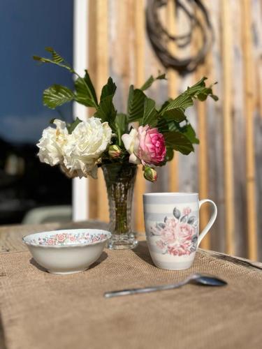 a table with a vase of flowers and a bowl at SOCOA LE CABANON in Lacanau