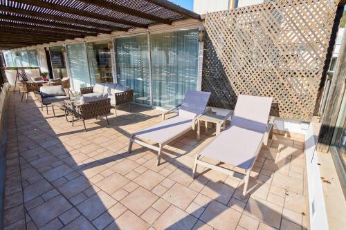 a patio with chairs and tables and windows at Los Geranios in Port de Soller