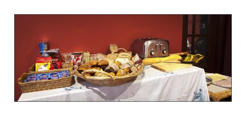 a table with baskets of food and bread on it at Hotel Rural en Escalante Las Solanas in Escalante