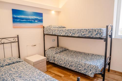 1 Schlafzimmer mit 2 Etagenbetten und einem Gemälde in der Unterkunft House I Gabbiani in Levanto
